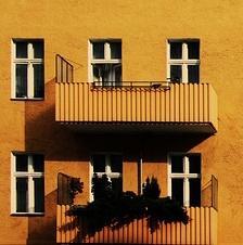 a yellow building with 2 balconies