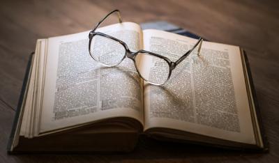 a pair of glasses on an open book